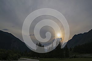 Storm dark clouds over mountain river valley with grass and rocks