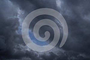 Storm dark grey cumulus clouds against blue sky background texture