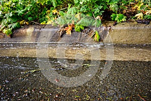 After the storm, floodwater running down a residential street on a sunny day