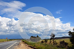 Storm forming over road through countryside