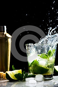 Storm in glass of Mojito with flying drops of cocktail