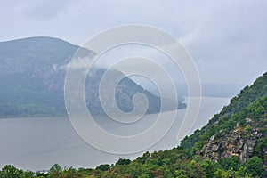 Storm King Mountain, seen from Hudson Highlands State Park across the Hudson River on a foggy and rainy day