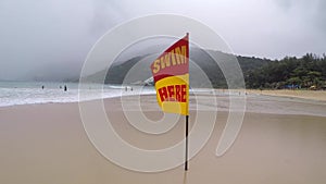 Storm at Nai Harn beach with surf life saving flag. Rain season Thailand. HD Gopro