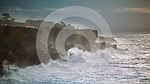 Storm ocean hitting rocky coastline. Powerful waves splashing making explosion