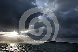 Storm over Portland Harbour with sun rays