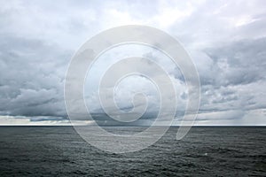 Before the storm. A painted view of storm and rain clouds and the sky above the sea horizon.