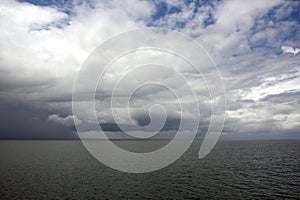 Before the storm. A painted view of storm and rain clouds and the sky above the sea horizon.