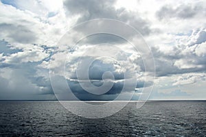 Before the storm. A painted view of storm and rain clouds and the sky above the sea horizon.