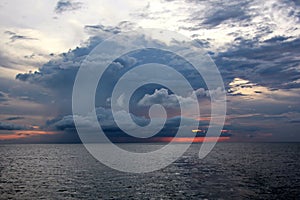 Before the storm. A painted view of storm and rain clouds and the sky above the sea horizon.