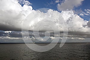 Before the storm. A painted view of storm and rain clouds and the sky above the sea horizon.