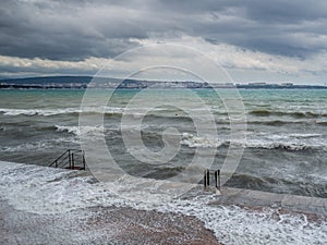 Bouře na středisku pobřeží bouře vlny jsou rozbíjení na molo. zakalený nebe a silný vítr 