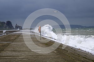 Storm on the sea. Pier flooded wave.