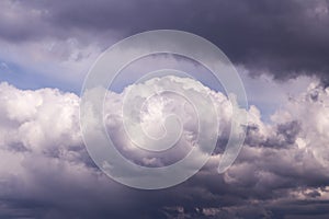 Storm sky. Dark grey, violet and white big cumulus rainy clouds on blue sky background, cloud texture, thunderstorm