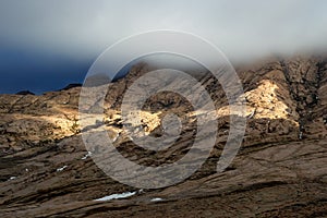 Storm sky and sunlight in desert mountains