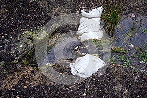 Stormwater management, inlet pipe for excess rainwater, sandbags, and garden plantings