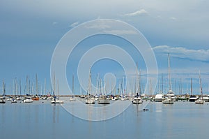 Stormy afternoon with a dark sky, and many sailboats moored in the Puertito del Buceo harbour photo