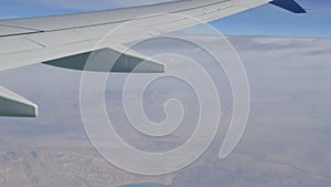 Stormy black clouds float across sky against the background of the wing of the airplane