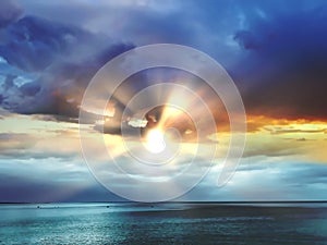 Stormy blue sky dramatic clouds and sun beams light at sea  at night  nature background