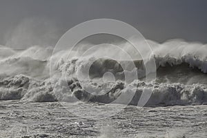 Stormy breaking waves with wind spray