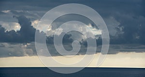 Stormy clouds with dramatic sky above the sea at sunset