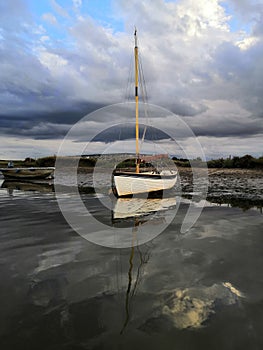 Stormy clouds and still waters, a boat on the shore
