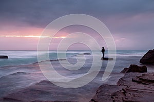 Stormy coast with a glimpse of sunrise through clouds