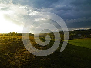 Stormy couds and sunset sky over fields