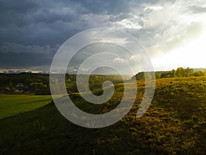 Stormy couds and sunset sky over fields