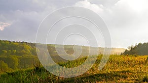 Stormy couds and sunset sky over fields