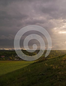 Stormy couds and sunset sky over fields