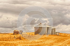 Stormy famland landscape of grain silos and old barns