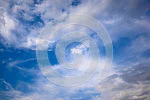 Stormy grey cloud with puffy white ones and blue sky. Horizontal cloudscape shot near horizon