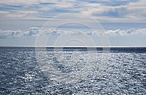 Stormy grey sea, calm before the storm, blue sky with some white