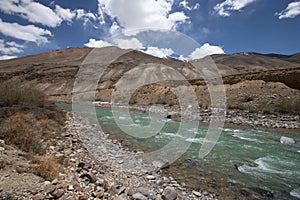 Stormy mountain river in valley in the foothills of the Fann mountains. Landscape.