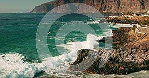 Stormy ocean landscape on rocky coastline with Los Gigantes cliffs in Tenerife Canary Islands. Slow-motion sea waves