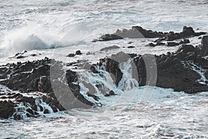 Stormy ocean is proving its strength. Waves crash against a rock during sunset in the Odemira region, western Portugal. Wandering