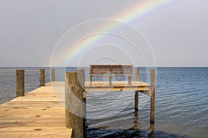 Stormy rainbow view from bench and pier