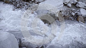 A stormy river of mountain water flows down through large stones