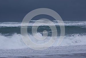 Stormy sea with dark navy blue skies and pounding surf