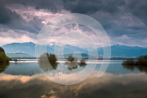 Stormy sky over the lake and mountaines with snow