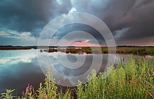 Stormy sunset sky over wild lake