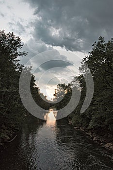 Stormy sunset on wooded river