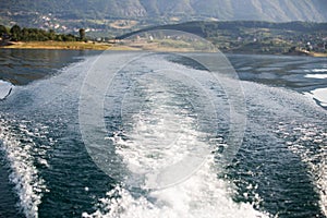 Stormy trace of motor boat crossing the emerald waters.