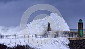 Stormy wave over old lighthouse and pier of Viavelez.