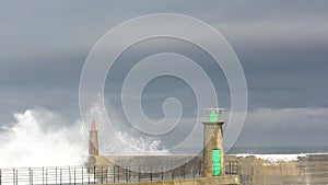 Stormy wave over old lighthouse and pier of Viavelez.