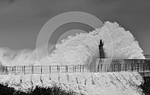 Stormy wave over old lighthouse and pier of Viavelez.