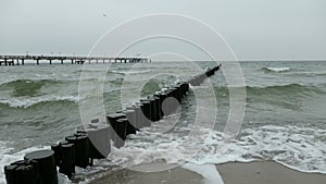 Stormy weather on Baltic sea beach. waves at the groynes and bubbles.