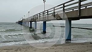 Stormy weather on Baltic sea beach. waves at the groynes and bubbles. in background sea bridge of Graal MÃƒÂ¼ritz Germany