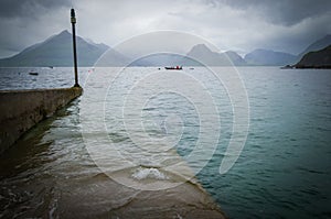 Stormy weather and a flooded boating dock in Elgol on Isle of Skye in Scotland