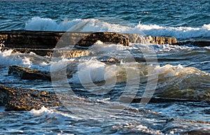 Stormy windy sea waves splashing on a rocky seashore